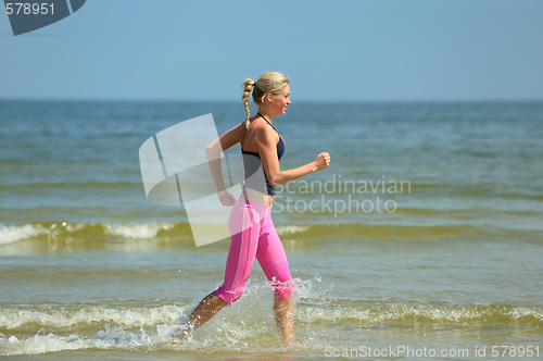 Image of Beautiful female running on the beach