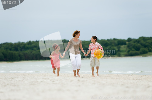 Image of Mother and kids walking on the beach