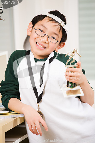 Image of Winning boy with his medal and trophy