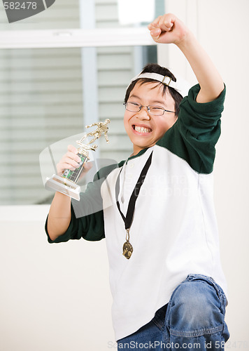 Image of Winning boy with his medal and trophy