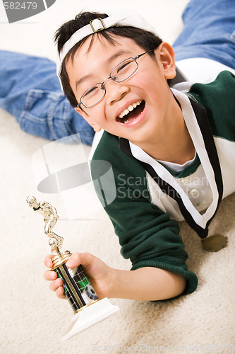 Image of Winning boy with his medal and trophy