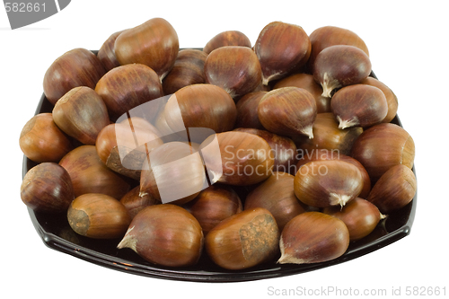 Image of Chestnuts on dark plate isolated on white background