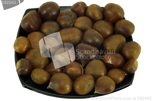 Image of Chestnuts on dark plate isolated on white background