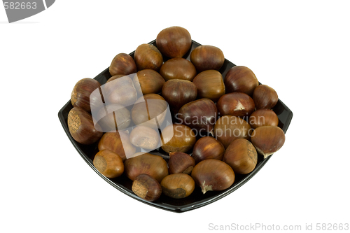 Image of Chestnuts on dark plate isolated on white background