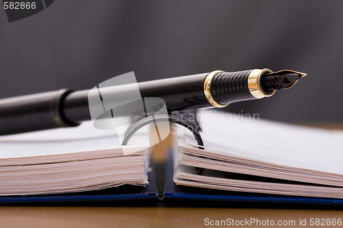 Image of pen over a notepad