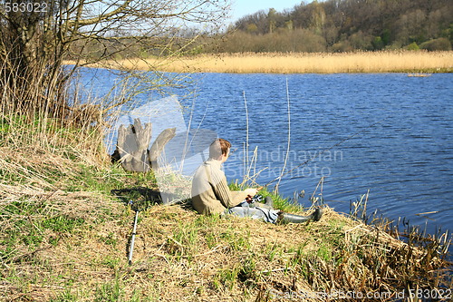 Image of Fisherman sitting on the river shore