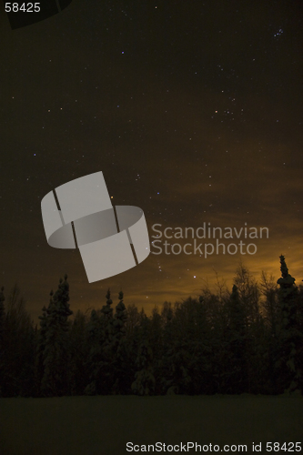 Image of Orion constellation near the horizon above town lights