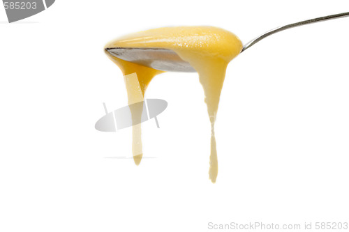 Image of Iron spoon flowing down honey