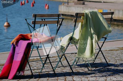 Image of two chairs from cafe on the city embankment