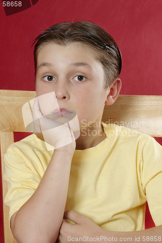 Image of Sitting boy resting head on hand