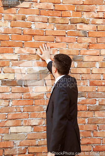 Image of Businessman by brick wall