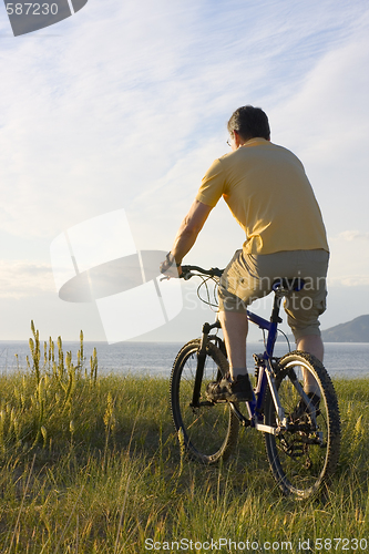 Image of Man riding bicycyle at the sea