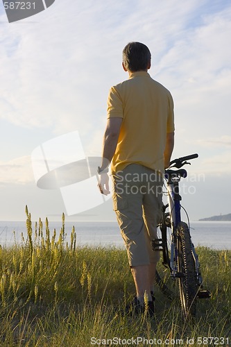 Image of Man with bicycle at the sea