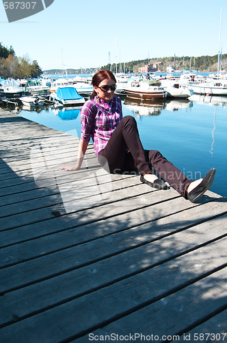 Image of Attractive young woman posing near the harbor