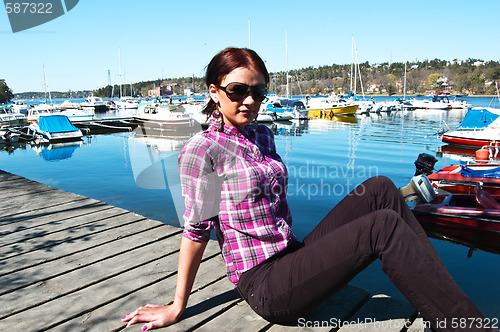 Image of Attractive young woman posing near the harbor
