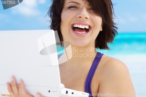 Image of woman with laptop computer on the beach