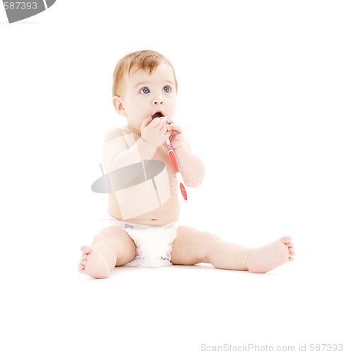 Image of baby boy in diaper with toothbrush