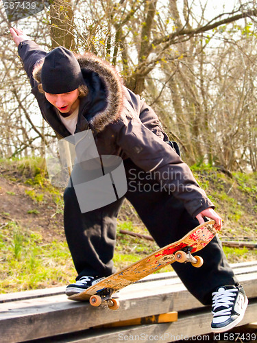 Image of Urban Lifestyle -Young teenage skatboarder doing tricks 