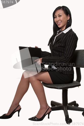 Image of Woman sitting and working on laptop