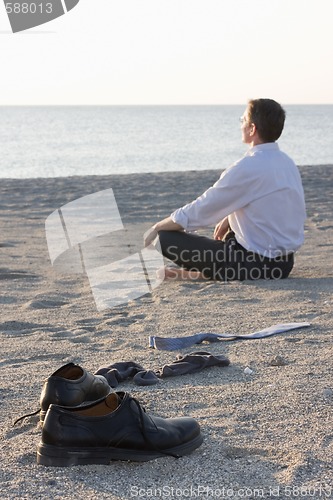Image of Businessman relaxing on a beach