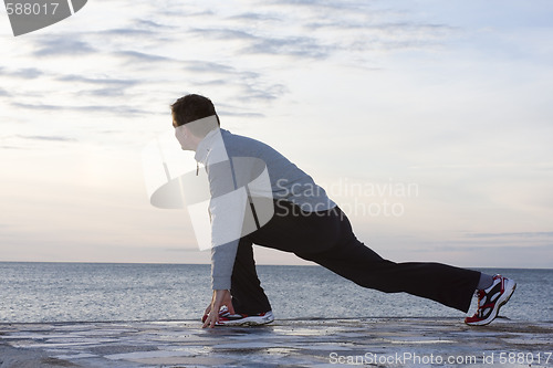 Image of Man doing exercises at the sea