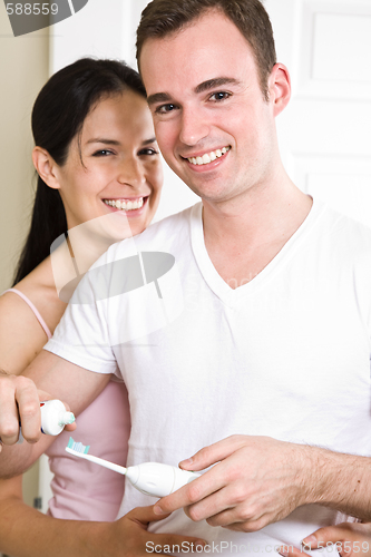 Image of Couple brushing teeth in the bathroom