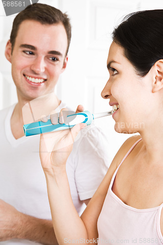Image of Couple brushing teeth in the bathroom