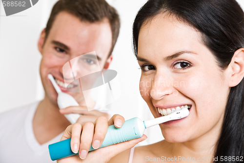 Image of Couple brushing teeth in the bathroom