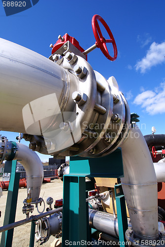 Image of industrial pipelines on pipe-bridge against blue sky   