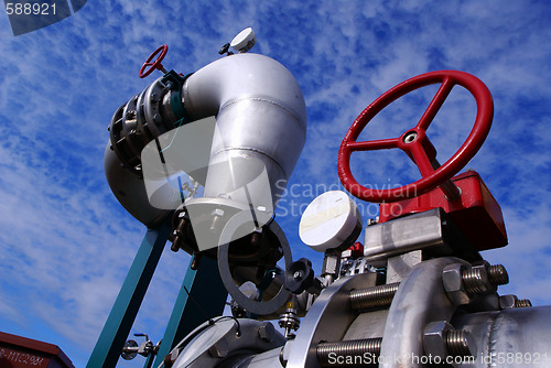 Image of industrial pipelines on pipe-bridge against blue sky   