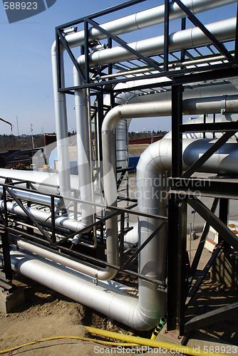 Image of industrial pipelines on pipe-bridge against blue sky 