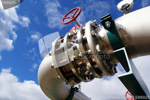 Image of Pipes, bolts, valves against blue sky 