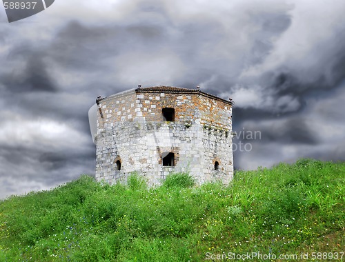 Image of Old stone tower over cloudy sky