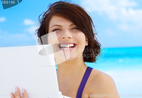 Image of woman with laptop computer on the beach