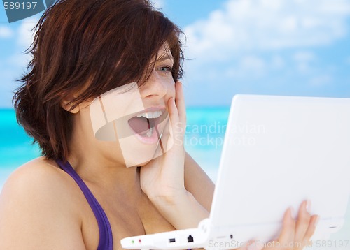 Image of woman with laptop computer on the beach