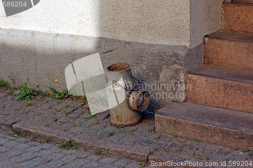 Image of Milk can on door step.