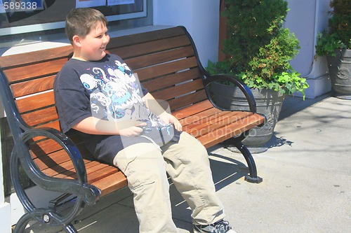 Image of Young boy sitting on bench