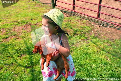 Image of Young girl holding puppy
