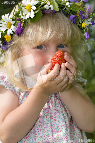 Image of little girl in flowers wreat with strawberries in hands