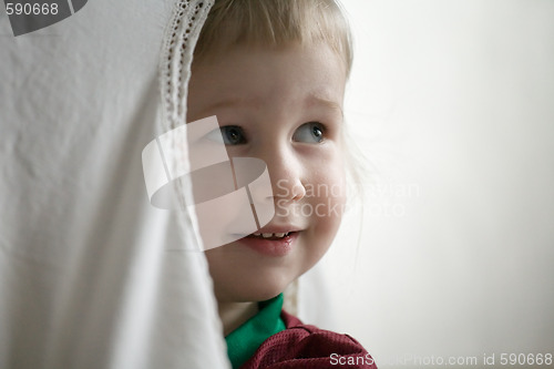 Image of little girl behind window curtain