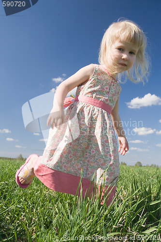 Image of happy little girl on green meadow