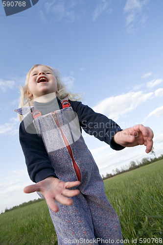 Image of happy little girl on green meadow