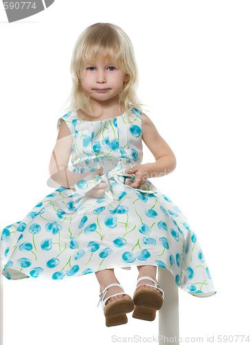 Image of small blond girl sits on white chair