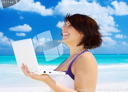 Image of woman with laptop computer on the beach