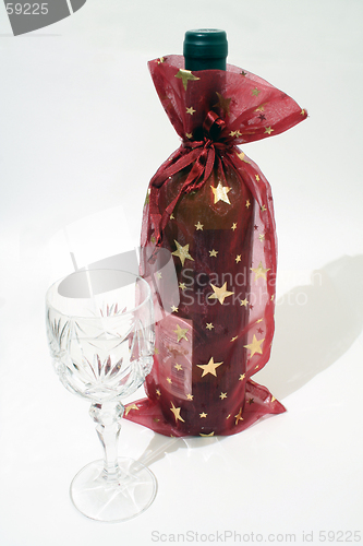 Image of Christmas decorated bottle of wine with glass on white background
