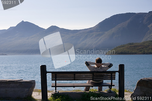 Image of relaxed man on the bank of lake