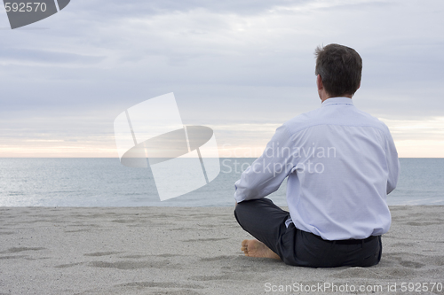 Image of Businessman meditating at the sea