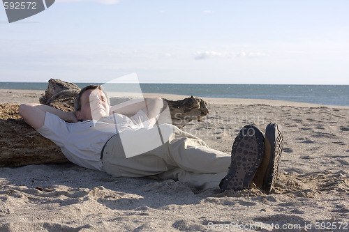 Image of Man sleeping on beach