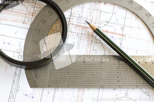 Image of blueprint with pencil, loupe and steel protractor