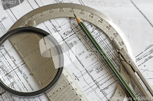 Image of blueprint with pencil, steel protractor, compass and loupe